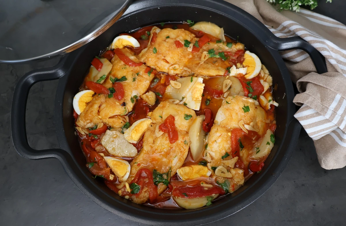 Cazuela con bacalao a la tranca zamorano: lomos de bacalao en ajada roja con pimientos asados, patatas guisadas, huevo duro y perejil fresco