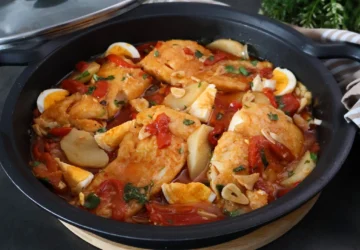 Cazuela con bacalao a la tranca terminado: lomos de bacalao en ajada roja con pimientos, patatas guisadas y huevo duro, receta tradicional