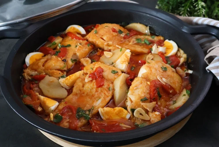 Cazuela con bacalao a la tranca terminado: lomos de bacalao en ajada roja con pimientos, patatas guisadas y huevo duro, receta tradicional