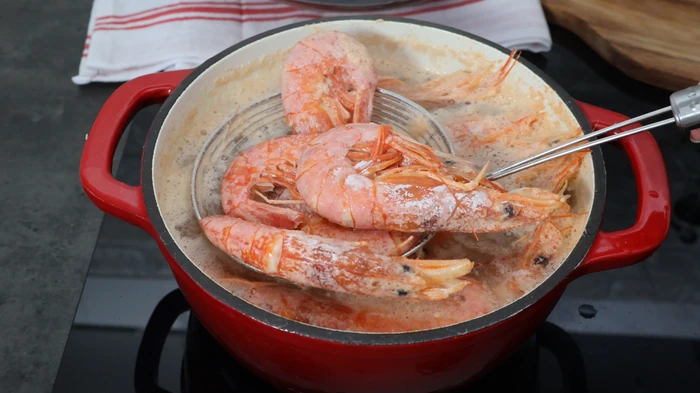 Cociendo gambones enteros en agua con sal para preparar el relleno y el caldo de los rissóis portugueses