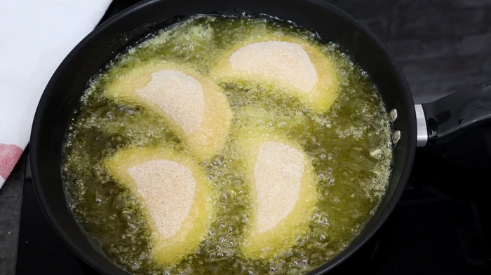 Rissóis portugueses friéndose en aceite a 170-175°C en tandas pequeñas para conseguir un dorado uniforme