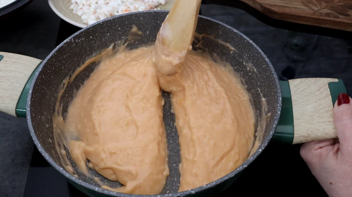 Textura perfecta de la bechamel con tomate para el relleno de rissóis portugueses: densa y con surco visible al pasar la espátula