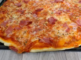Pizza casera en primer plano mostrando queso mozzarella derretido, ingredientes y masa dorada