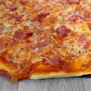 Pizza casera en primer plano mostrando queso mozzarella derretido, ingredientes y masa dorada