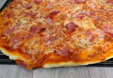 Pizza casera en primer plano mostrando queso mozzarella derretido, ingredientes y masa dorada