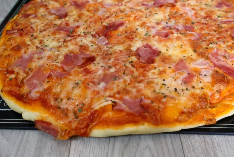 Pizza casera en primer plano mostrando queso mozzarella derretido, ingredientes y masa dorada