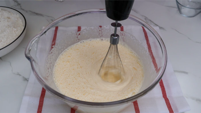 Mezcla de huevos y azúcar blanqueando para bizcocho casero de aceite