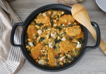 Potaje de vigilia con garbanzos espinacas bacalao y rellenos crujientes en cazuela vista cenital con cuchara de madera