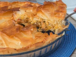 Pastel de pollo griego kotopita con masa filo crujiente y porción levantada mostrando el relleno de pollo, queso y verduras