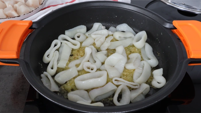 Añadir los calamares al sofrito para el guiso en salsa verde
