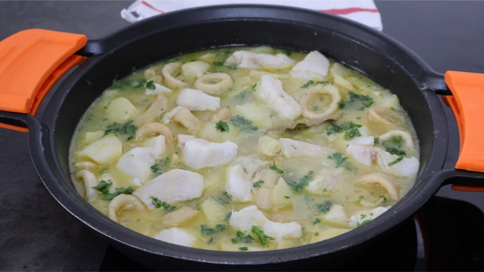 Guiso de merluza y calamares con patatas tras añadir el majado