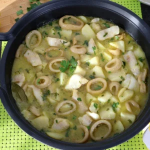 Cazuela de merluza y calamares con patatas en salsa verde vista cenital