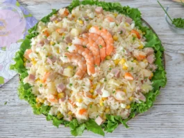 Ensalada de arroz con langostinos, jamón de york, piña, maíz y huevo sobre cama de lechuga