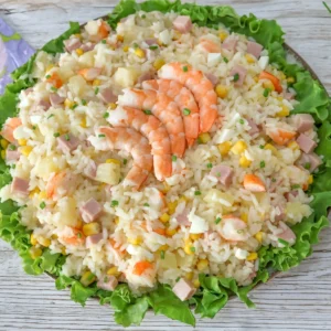 Ensalada de arroz con langostinos, jamón de york, piña, maíz y huevo sobre cama de lechuga