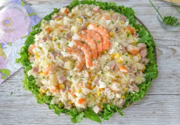 Ensalada de arroz con langostinos, jamón de york, piña, maíz y huevo sobre cama de lechuga