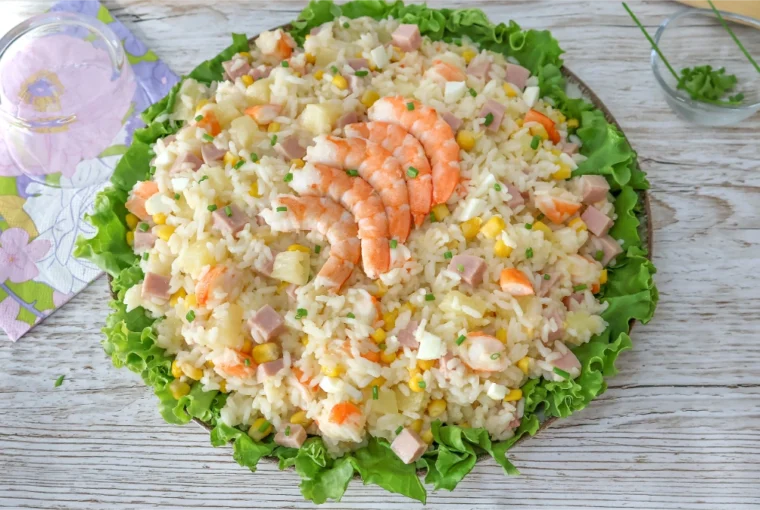 Ensalada de arroz con langostinos, jamón de york, piña, maíz y huevo sobre cama de lechuga
