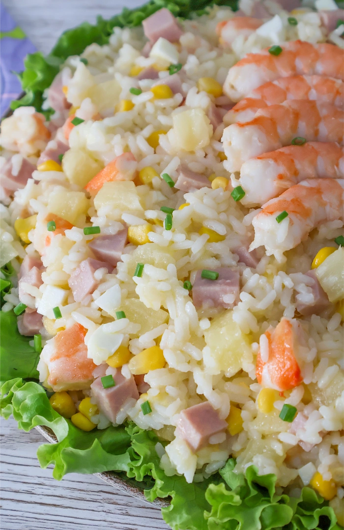 Primer plano de ensalada de arroz con langostinos, jamón de york, piña, maíz y cebollino