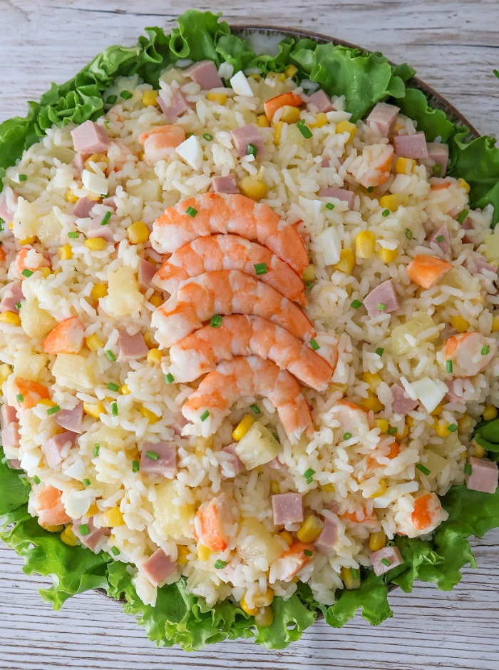 Ensalada de arroz con piña, langostinos en abanico, jamón de york, maíz y huevo sobre lechuga