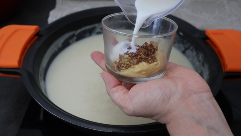 Mostaza de Dijon y mostaza a la antigua en un vaso, añadiendo la leche reservada para disolverlas