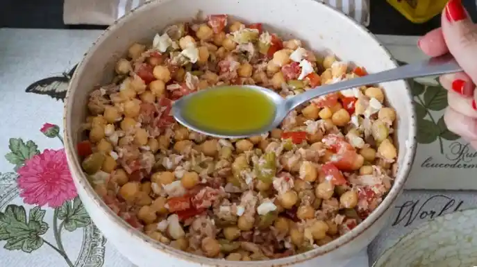 Cucharada de vinagreta clásica aliñando una ensalada de garbanzos