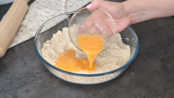 Añadiendo el huevo a la mezcla de solidos y mantequilla para terminar la masa