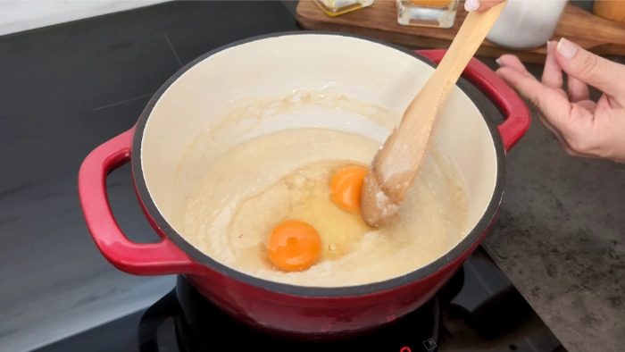 Añadiendo los huevos a la crema de queso y mantequilla