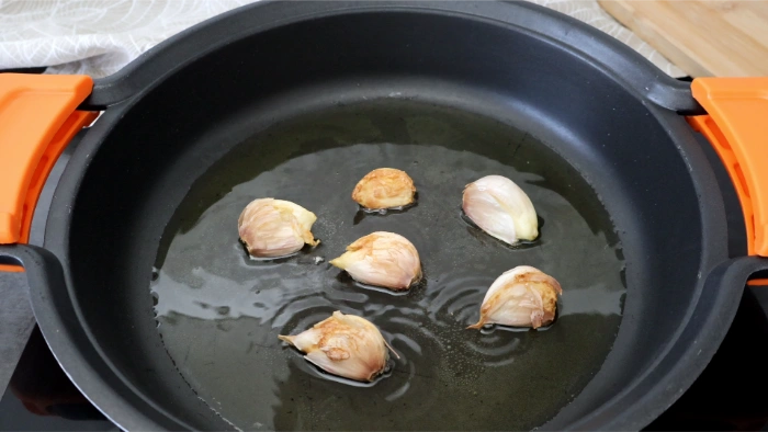 Ajos dorándose en aceite antes de marcar la carne de cerdo
